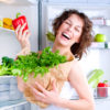 Dieting concept .Diet. Beautiful Young Woman near the Refrigerator with healthy food. Fruits and Vegetables