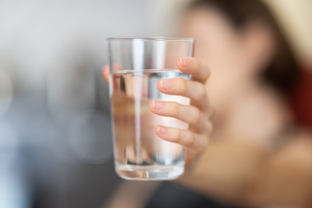 holding clear drinking glass